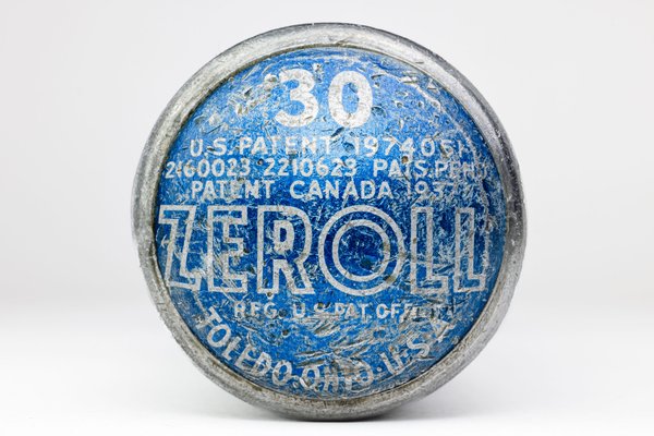 A round, blue and silver end of an ice cream scoop with worn-off text. The text includes "ZEROLL," "TOLEDO, OHIO, U.S.A.," and patent numbers. The number "30" is prominently displayed in white. The surface shows signs of age and wear, with scratches and faded areas.